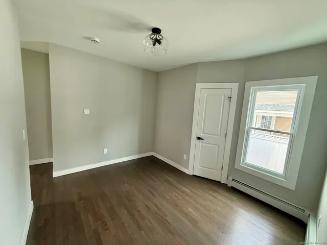 an empty room with wooden floor and window