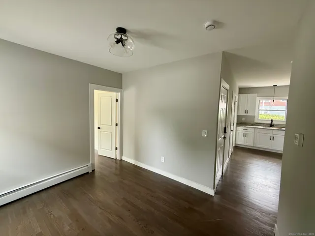 an empty room with wooden floor and a ceiling fan