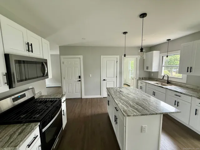 a kitchen with granite countertop counter space a sink appliances and cabinets