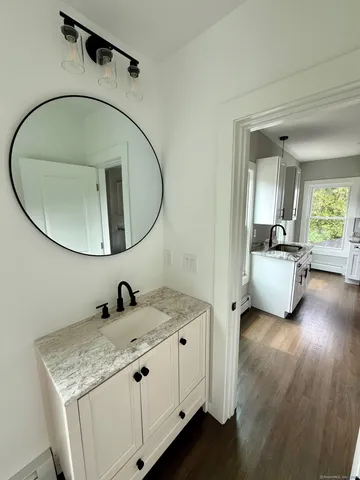 a en suite bathroom with a granite countertop sink and a mirror
