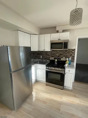 a kitchen with granite countertop a refrigerator and a stove