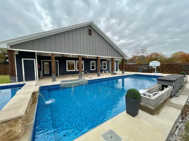 a view of a house with pool lawn chairs and wooden floor