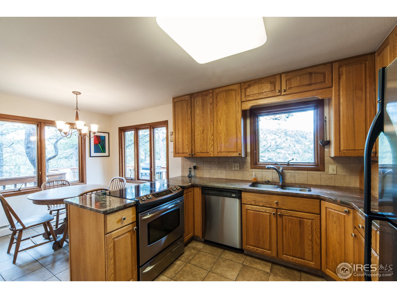 229 Kelly Road East Boulder, CO 80302 - Photo 10 of 25 a kitchen with granite countertop a sink stove and cabinets