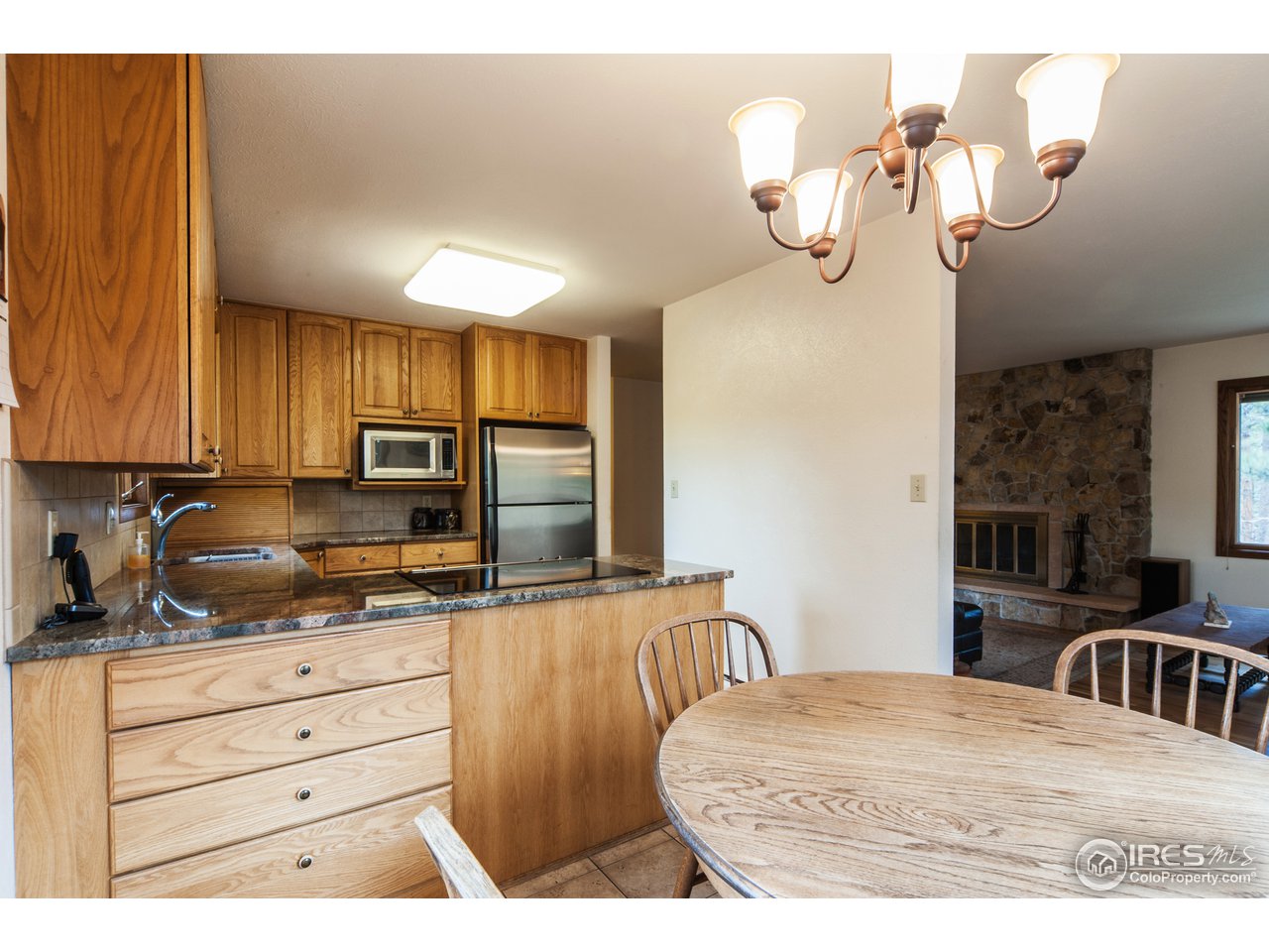 229 Kelly Road East Boulder, CO 80302 - Photo 11 of 25 a kitchen with stainless steel appliances a stove a microwave a refrigerator and cabinets