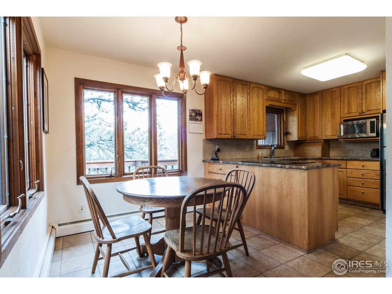 229 Kelly Road East Boulder, CO 80302 - Photo 12 of 25 a dining room with furniture a chandelier and kitchen view