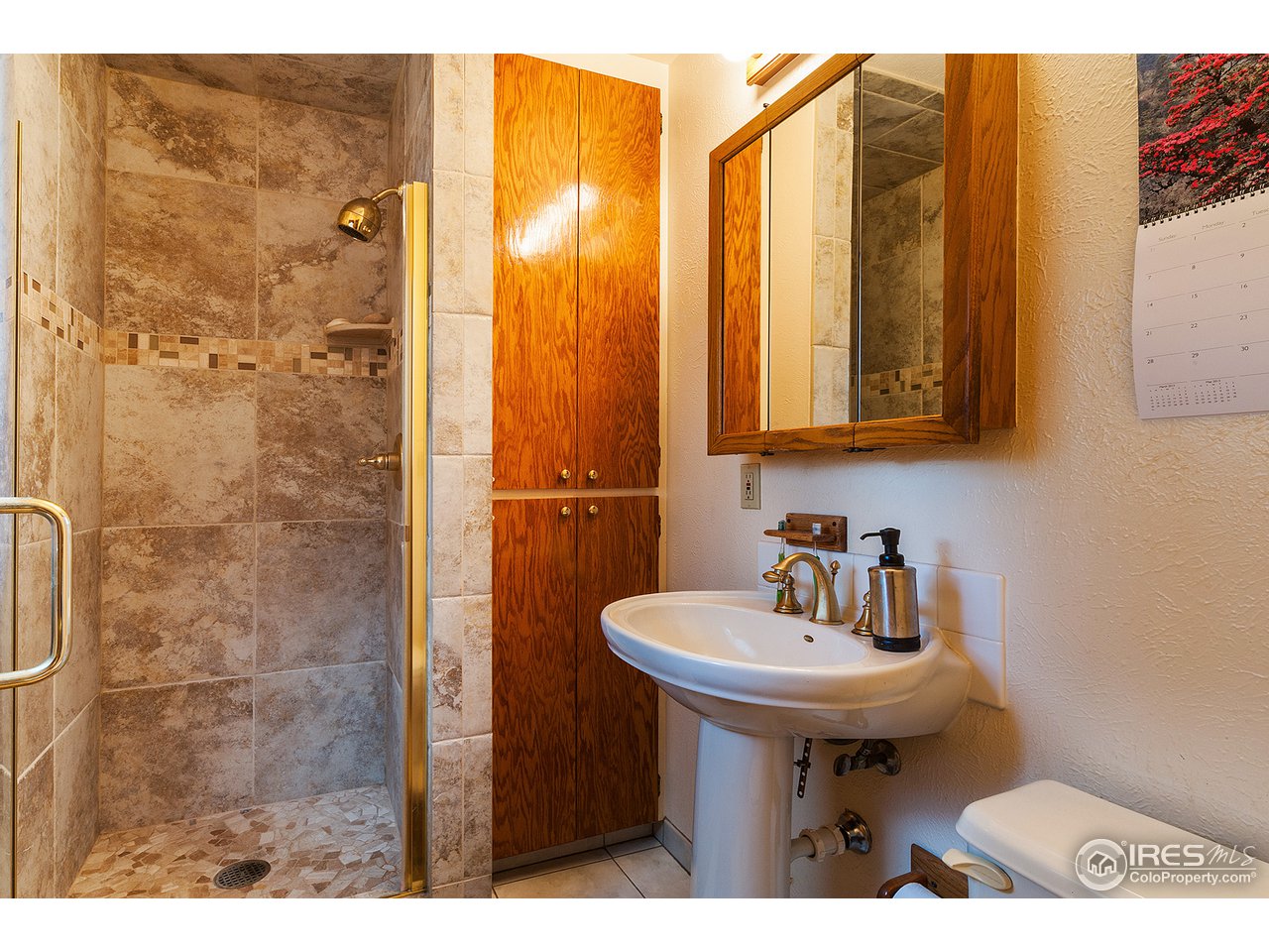 229 Kelly Road East Boulder, CO 80302 - Photo 14 of 25 a bathroom with a sink a mirror and shower