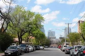 a city street lined with parked cars and buildings