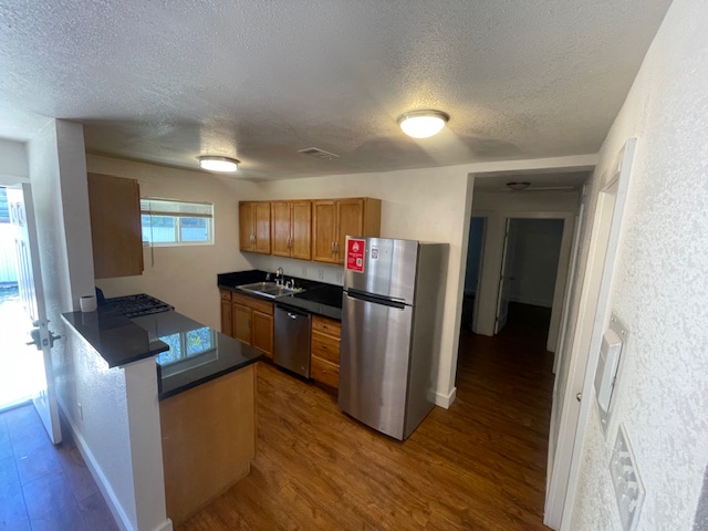 1113 East 3rd Street, Unit A Austin, TX 78702 - Photo 4 of 12 a kitchen with granite countertop a refrigerator and a stove top oven