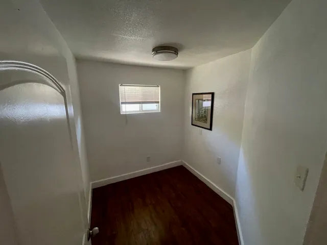 a view of an empty room with wooden floor