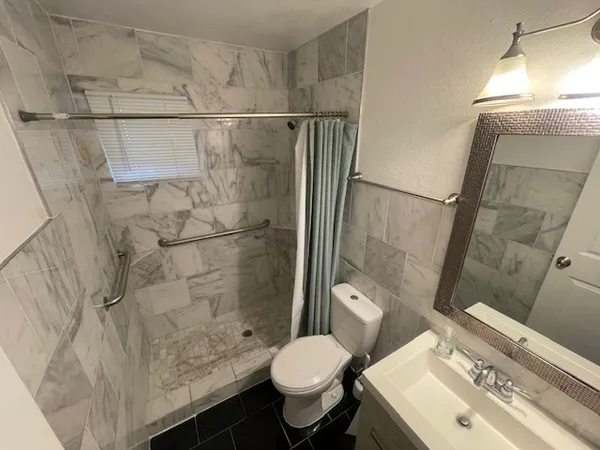 a bathroom with a sink toilet and shower