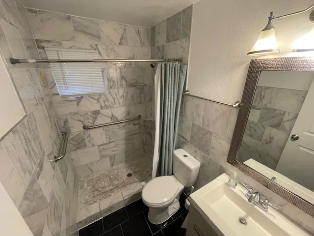a bathroom with a sink toilet and shower