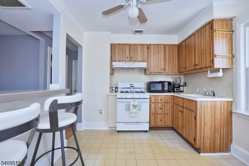 103 Orchard Street, Unit 2 Summit, NJ 07901 - Photo 10 of 17 a kitchen with stainless steel appliances granite countertop a stove a sink dishwasher and cabinets with wooden floor