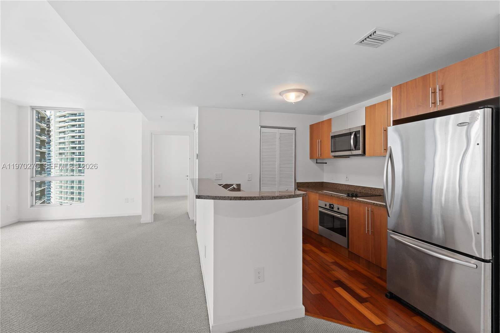 300 South Biscayne Boulevard, Unit T2602 Miami, FL 33131 - Photo 6 of 17 a kitchen with stainless steel appliances granite countertop a refrigerator a stove a sink and a refrigerator