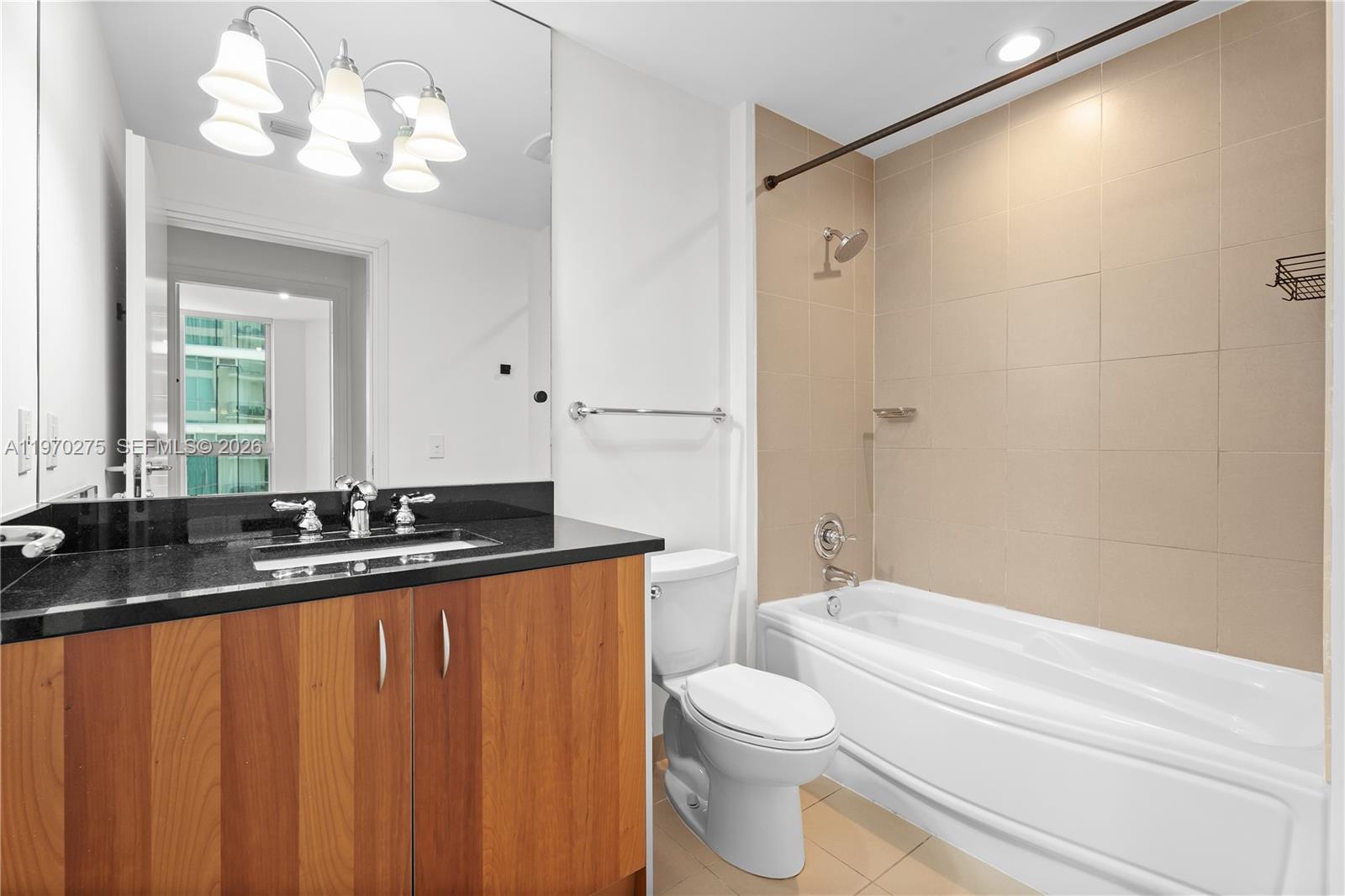 300 South Biscayne Boulevard, Unit T2602 Miami, FL 33131 - Photo 10 of 17 a bathroom with a granite countertop sink a toilet a mirror and shower