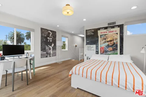 a bedroom with a bed and wooden floor