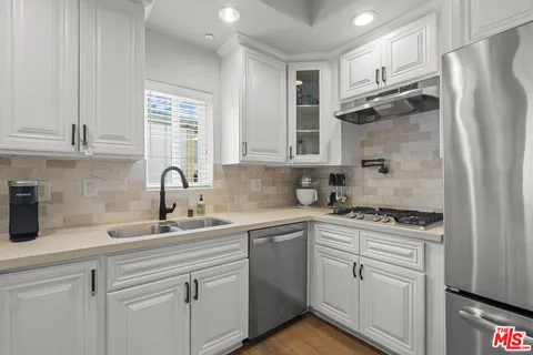 a kitchen with white cabinets and a refrigerator