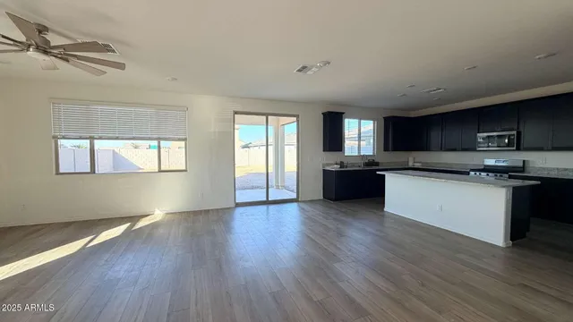 a kitchen with granite countertop a refrigerator and a stove top oven