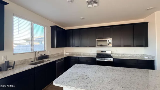 a kitchen with stainless steel appliances a sink and a stove top oven