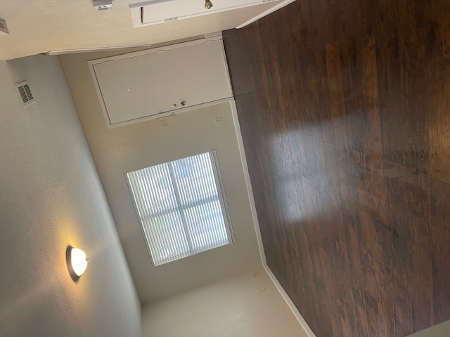 908 Guadalupe Street Lockhart, TX 78644 - Photo 2 of 8 an empty room with wooden floor and windows