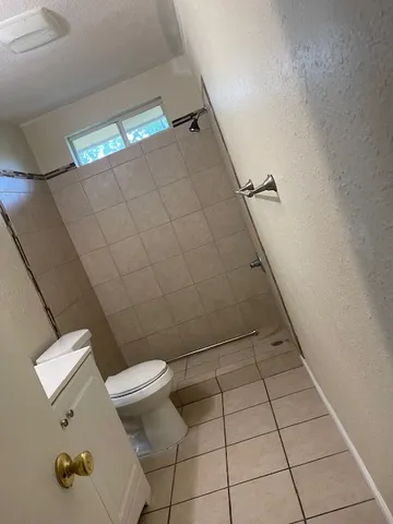 a bathroom with a toilet and a shower