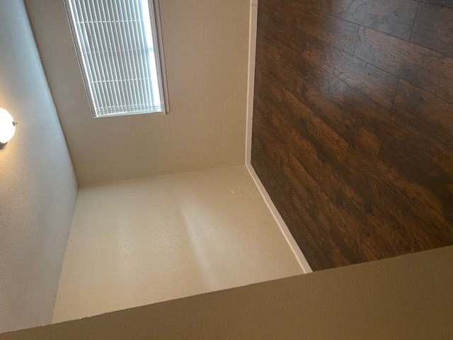 908 Guadalupe Street Lockhart, TX 78644 - Photo 8 of 8 an empty room with wooden floor and windows