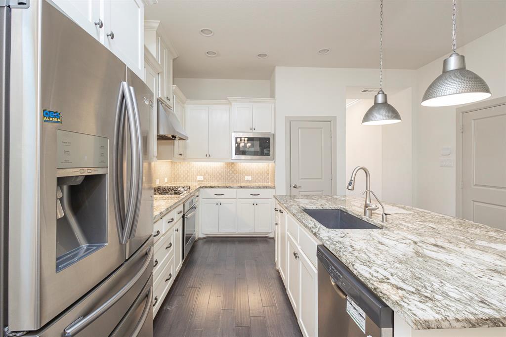 6337 Saddlebrook Way Irving, TX 75039 - Photo 11 of 40 a kitchen with granite countertop a sink stove refrigerator and cabinets
