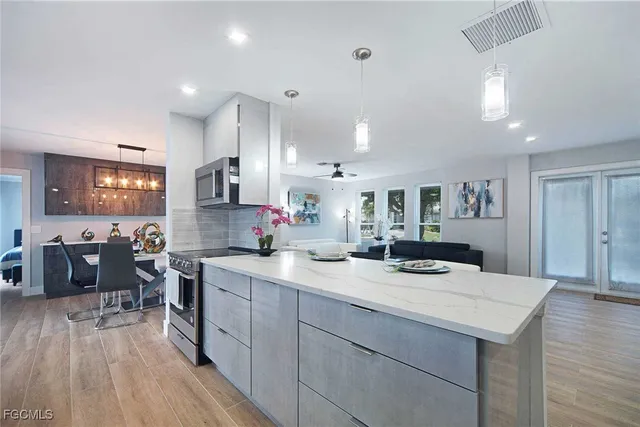 a kitchen with a sink a counter space dining table and chairs