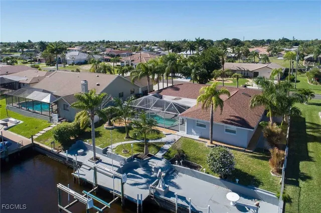 an aerial view of a house with a garden and lake view