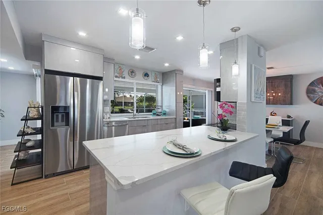 a kitchen with stainless steel appliances kitchen island granite countertop a dining table and chairs