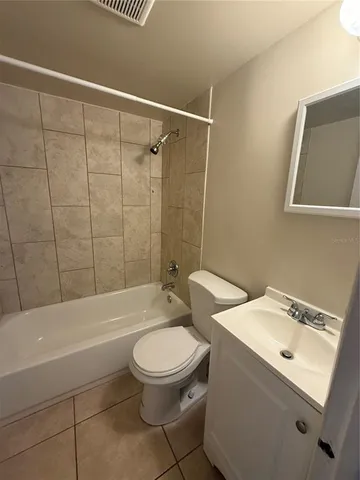 a white toilet sitting next to a bath tub