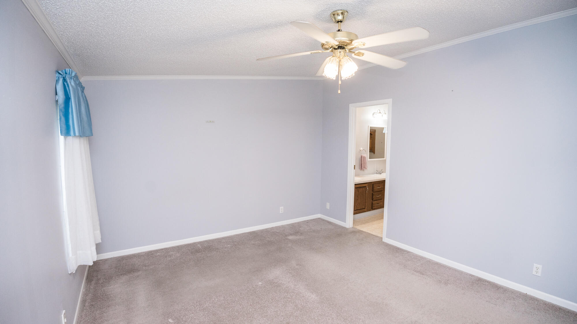 125 Red Eye Road DeFuniak Springs, FL 32433 - Photo 13 of 50 an empty room with a chandelier fan and windows