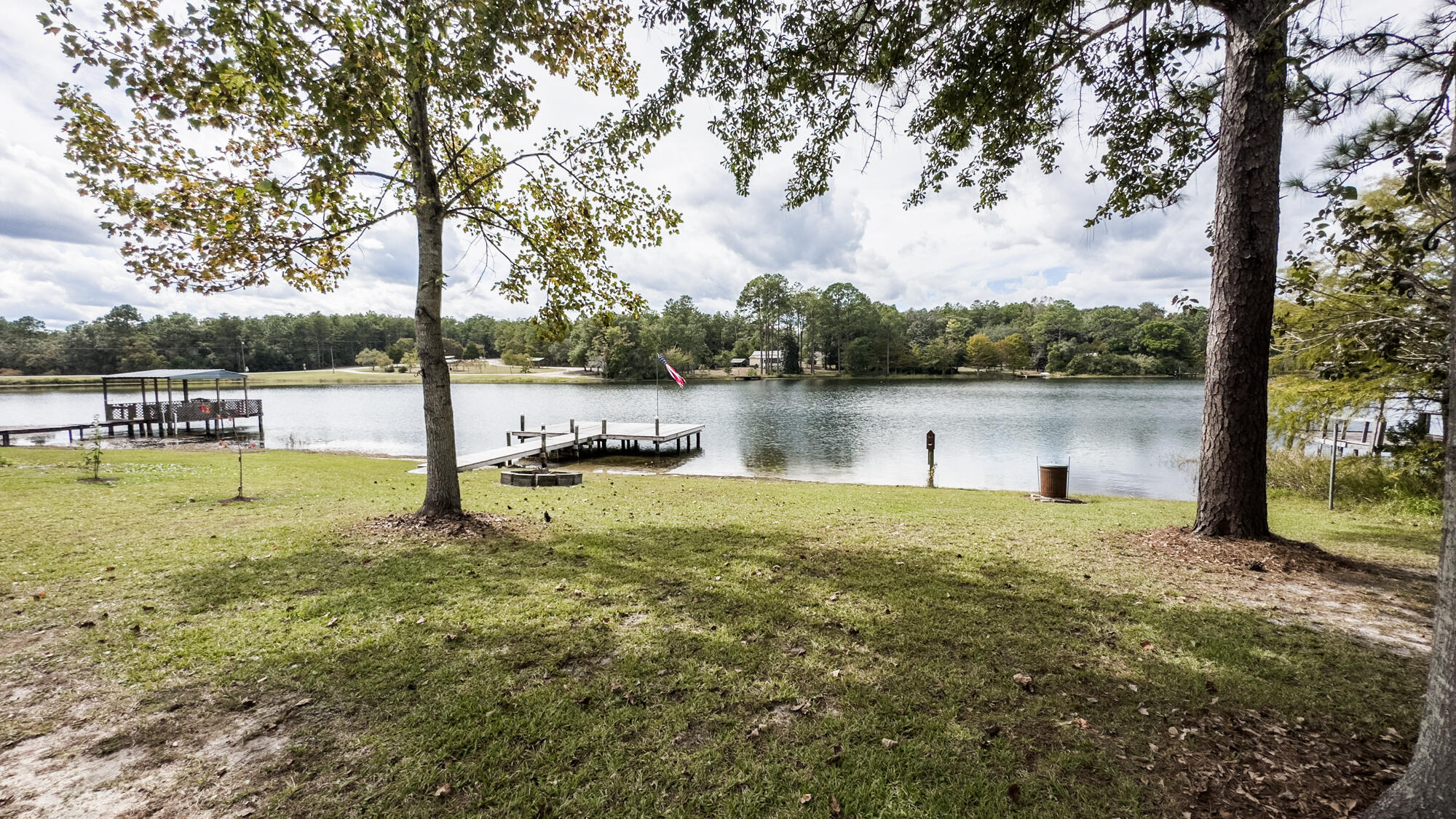 125 Red Eye Road DeFuniak Springs, FL 32433 - Photo 41 of 50 a view of a lake with a bench and trees