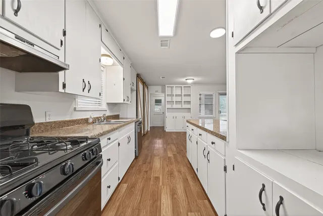 a large kitchen with stainless steel appliances granite countertop a stove and a refrigerator