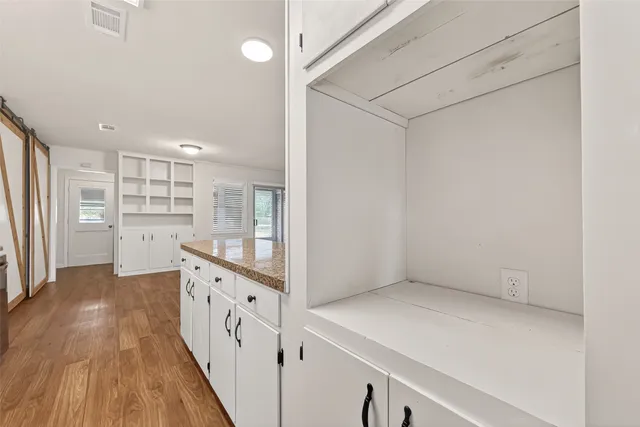 a kitchen with cabinets and wooden floor