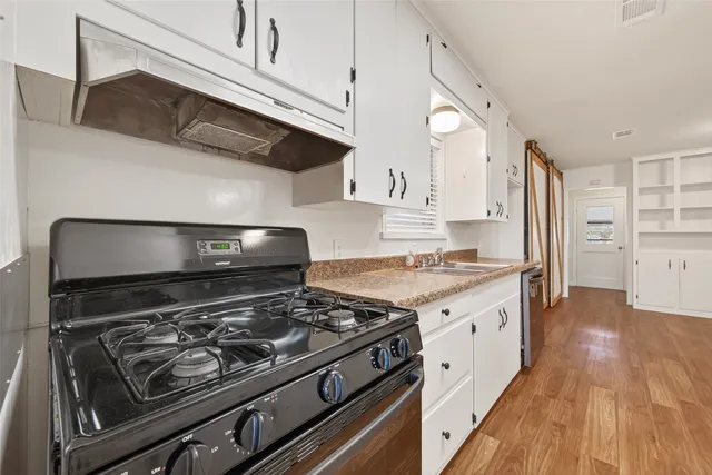 a kitchen with stainless steel appliances granite countertop a stove and a wooden cabinets