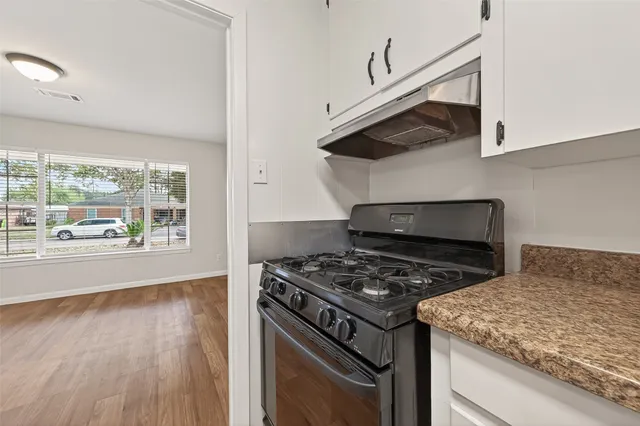 a kitchen with stainless steel appliances granite countertop a stove and a wooden cabinets