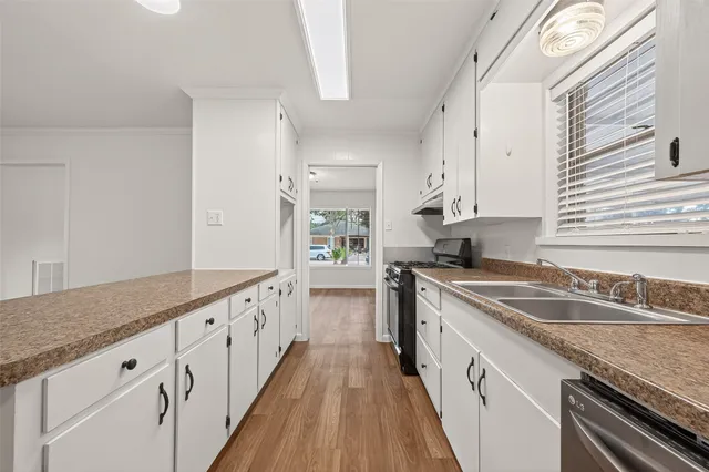 a kitchen with granite countertop a sink stove and cabinets