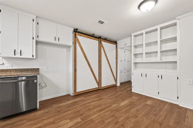 a view of a kitchen with wooden floor and electronic appliances
