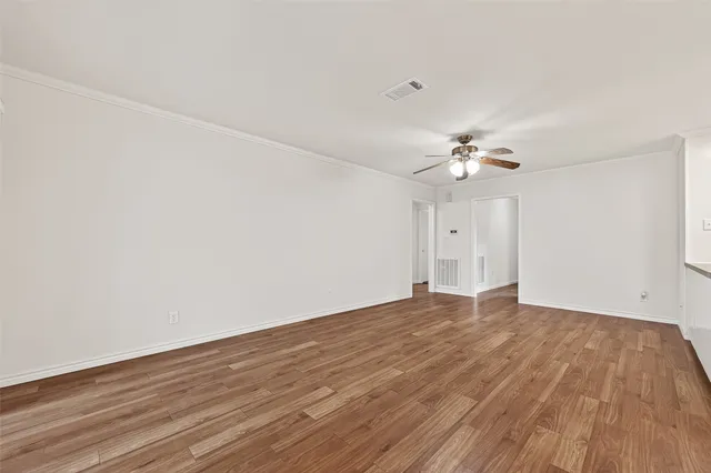 a view of an empty room with wooden floor