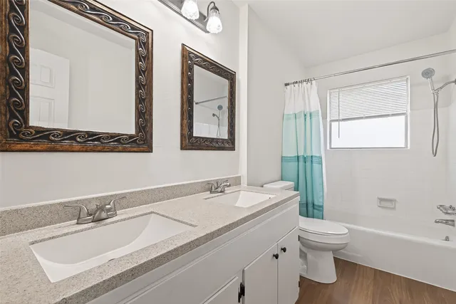 a bathroom with a granite countertop sink mirror and a toilet