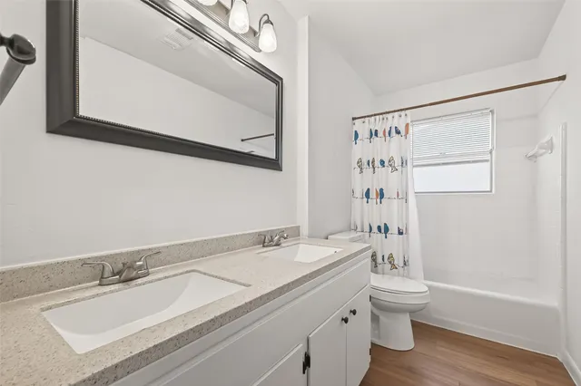 a bathroom with a granite countertop sink a toilet and a bathtub