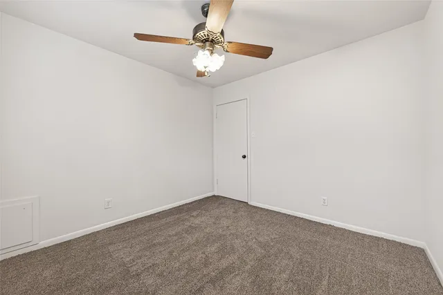 an empty room with a chandelier fan