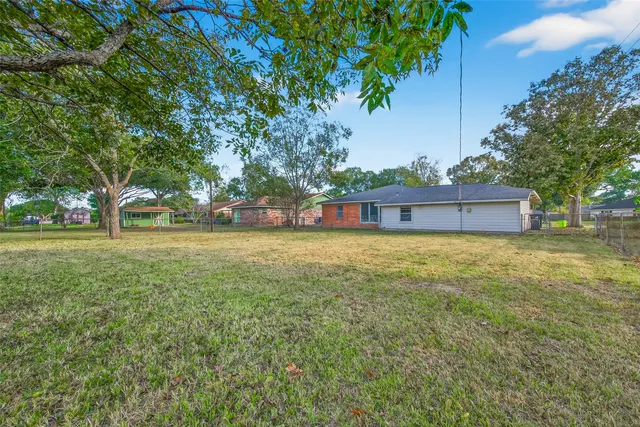a view of a green field with wooden fence
