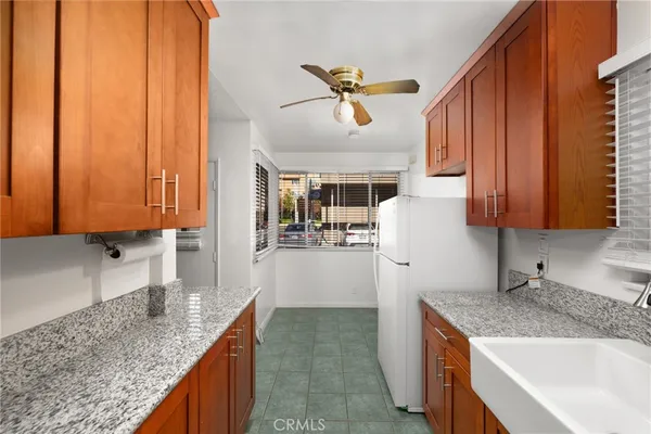 a kitchen with stainless steel appliances granite countertop a sink dishwasher stove and refrigerator with wooden floor