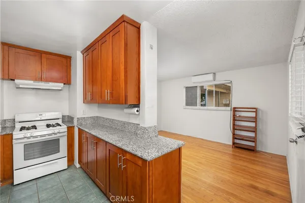 a kitchen with a stove and a wooden cabinets