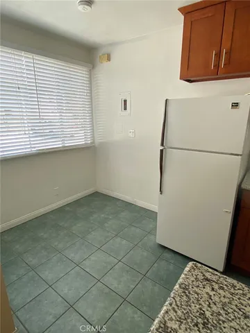 a view of a refrigerator in kitchen and a window