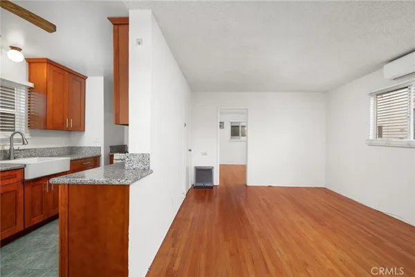 a kitchen with granite countertop a sink and wooden floor