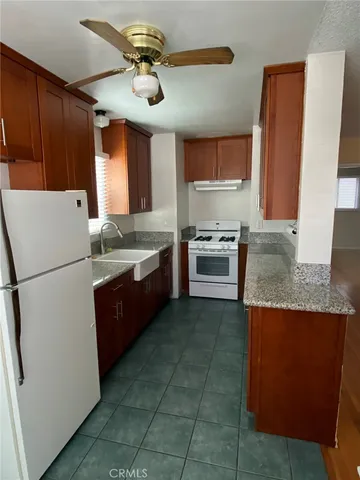 a kitchen with a stove a refrigerator and a sink