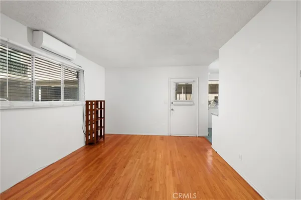 a view of empty room with wooden floor and windows