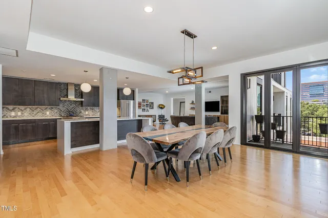 a view of a dining room and livingroom with furniture wooden floor a chandelier
